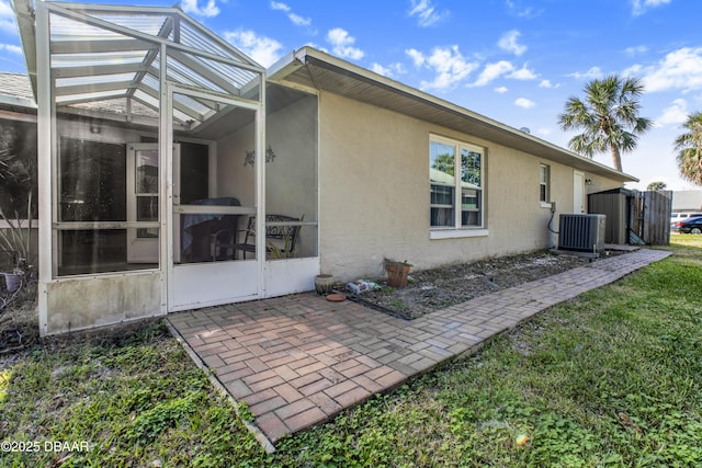 rear view of house with a lanai, central AC, and a patio area