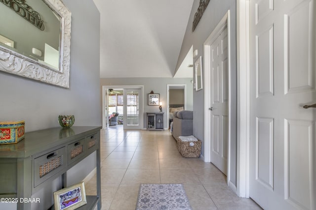 hall featuring lofted ceiling and light tile patterned flooring