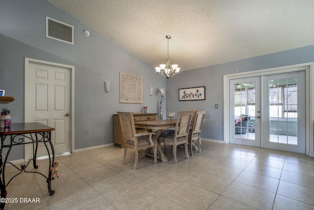 tiled dining space featuring a textured ceiling, vaulted ceiling, french doors, and a chandelier