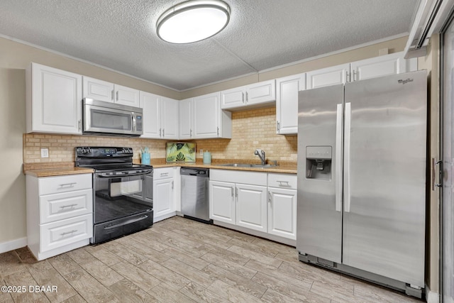 3824 Saxon Dr, New Smyrna Beach, FL 32169 - kitchen with appliances with stainless steel finishes, light countertops, white cabinetry, a textured ceiling, and decorative backsplash