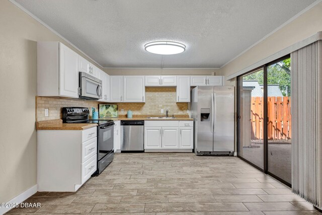 3824 Saxon Dr, New Smyrna Beach, FL 32169 - kitchen featuring appliances with stainless steel finishes, ornamental molding, a textured ceiling, light countertops, and backsplash
