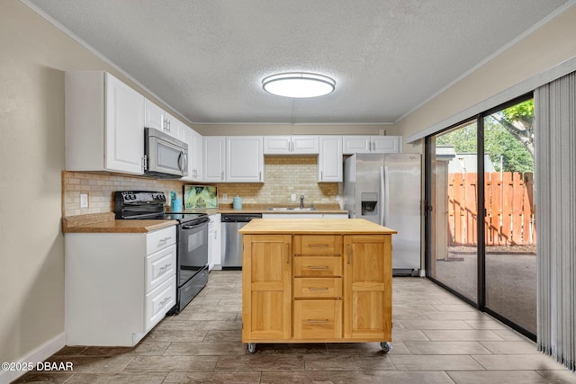 3824 Saxon Dr, New Smyrna Beach, FL 32169 - kitchen featuring appliances with stainless steel finishes, a textured ceiling, ornamental molding, tasteful backsplash, and white cabinetry