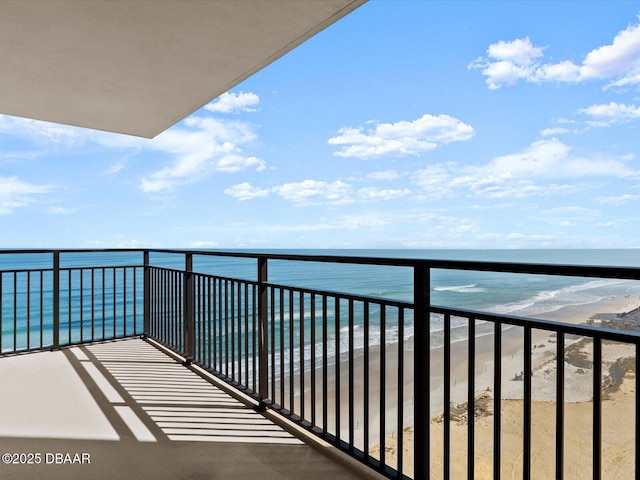 balcony with a water view and a beach view