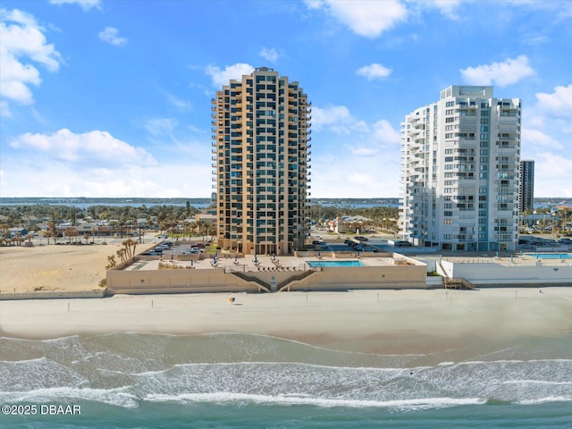 drone / aerial view featuring a water view and a view of the beach