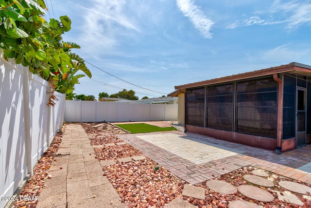 view of yard with a sunroom and a patio