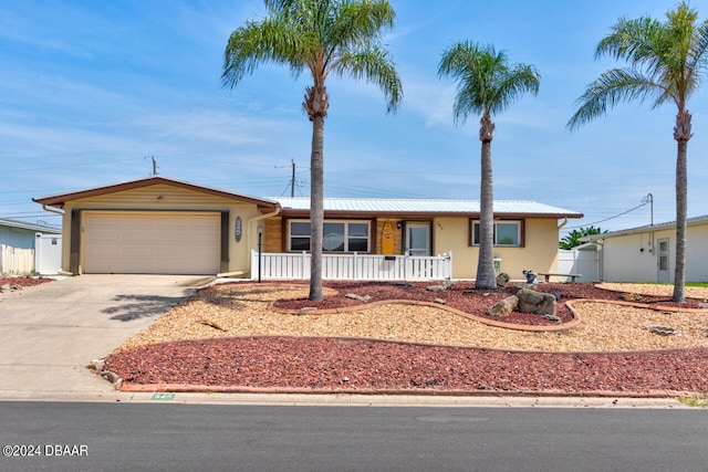 single story home featuring covered porch and a garage