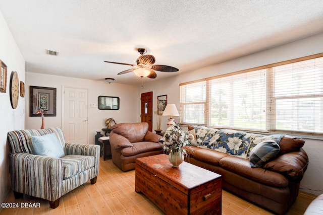 living room featuring a textured ceiling, plenty of natural light, and ceiling fan