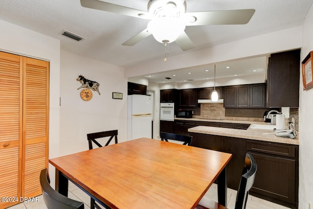 dining space featuring light tile patterned floors, a textured ceiling, ceiling fan, and sink