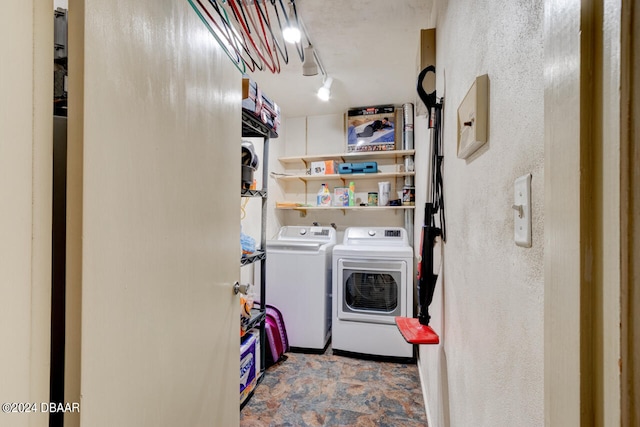 laundry area with washer and dryer and rail lighting