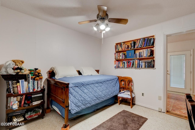 bedroom with ceiling fan and a textured ceiling