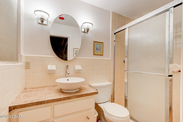 bathroom with vanity, tile walls, and walk in shower