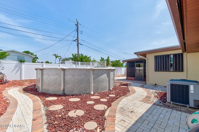 view of yard with a fenced in pool, central air condition unit, and a patio area