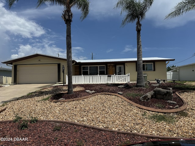 ranch-style house featuring covered porch and a garage