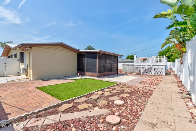 view of yard with a sunroom, central AC unit, and a patio area