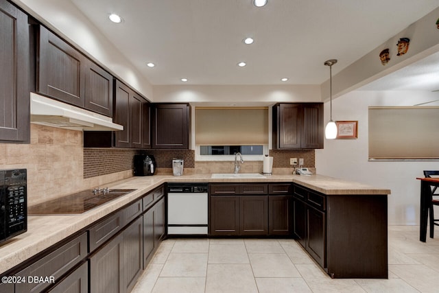 kitchen featuring sink, kitchen peninsula, pendant lighting, light tile patterned floors, and black appliances