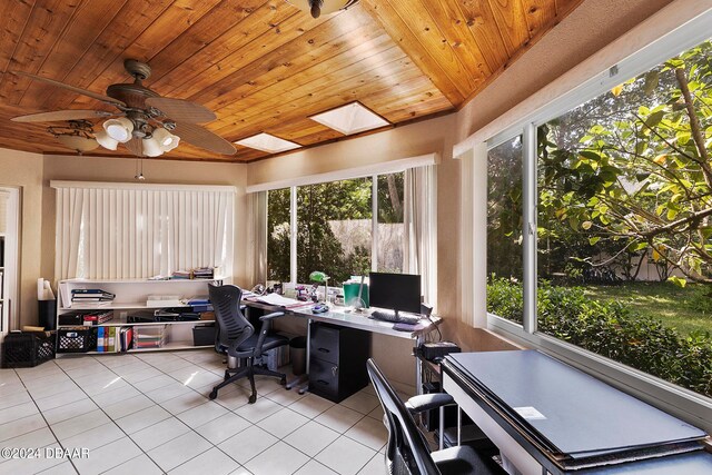 tiled office space featuring ceiling fan, wood ceiling, and a skylight