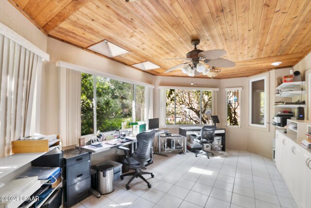 tiled home office featuring ceiling fan, a skylight, and wooden ceiling