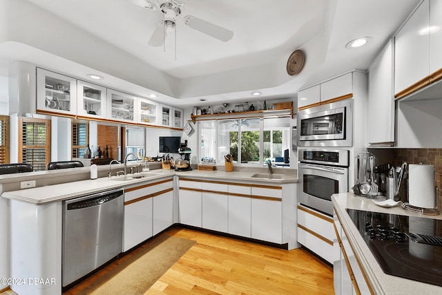 kitchen with white cabinets, sink, ceiling fan, light wood-type flooring, and appliances with stainless steel finishes