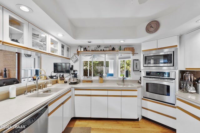 kitchen featuring white cabinets, light hardwood / wood-style floors, sink, and appliances with stainless steel finishes