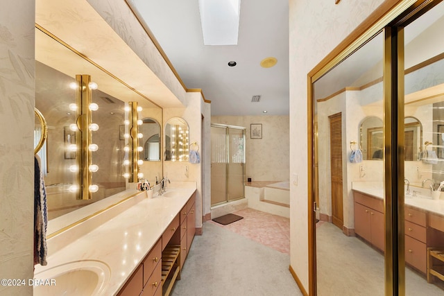 bathroom featuring a skylight, independent shower and bath, and vanity