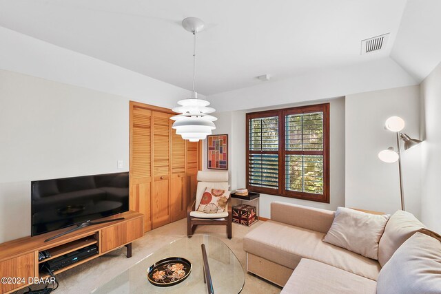 living room featuring vaulted ceiling and an inviting chandelier