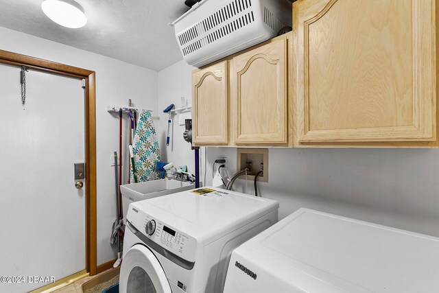 laundry room featuring cabinets, sink, and independent washer and dryer