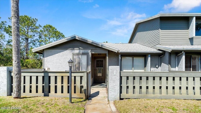 view of front of property with stucco siding and fence