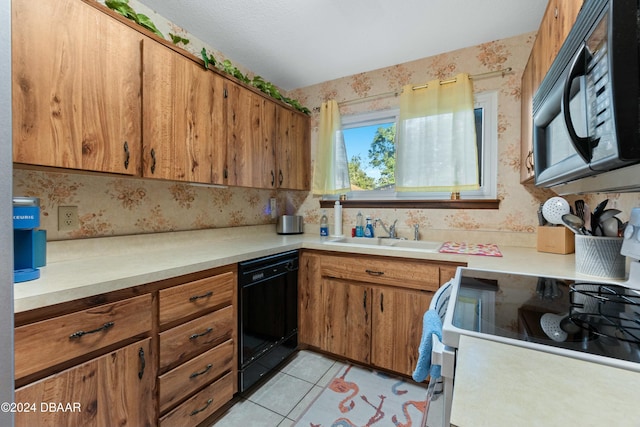 kitchen featuring light tile patterned flooring, sink, and black appliances