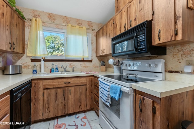 kitchen featuring black appliances, light tile patterned floors, and sink