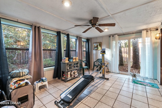 exercise area with ceiling fan and light tile patterned floors