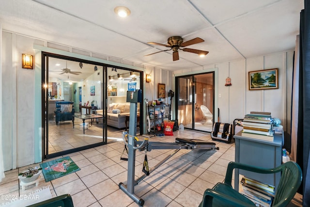 exercise area with ceiling fan and light tile patterned floors