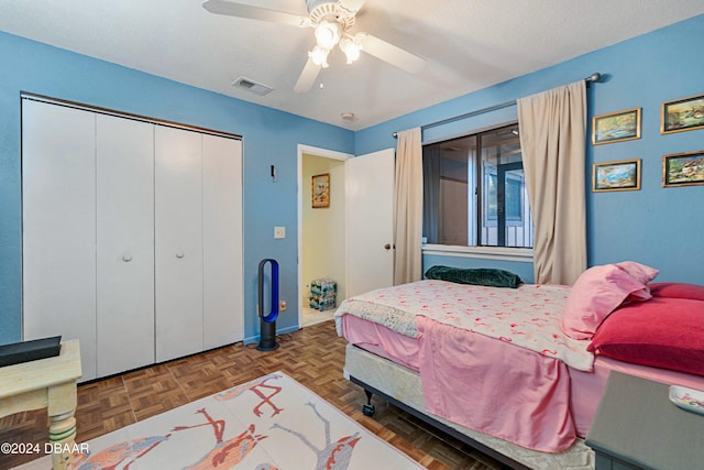 bedroom featuring parquet flooring, a textured ceiling, a closet, and ceiling fan