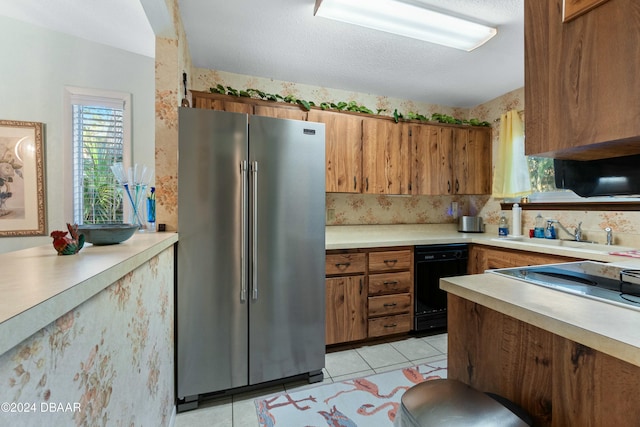 kitchen with stainless steel fridge, a textured ceiling, sink, black dishwasher, and light tile patterned flooring