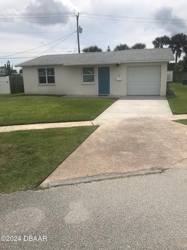 ranch-style home featuring a garage and a front lawn