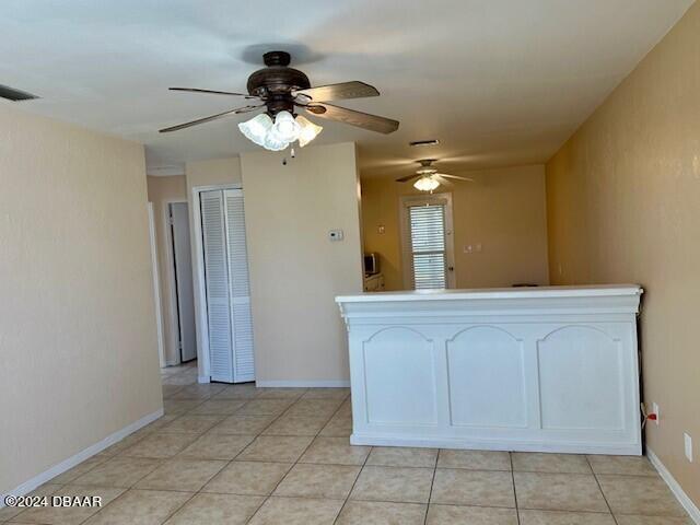 kitchen with white cabinetry, light tile patterned floors, and ceiling fan