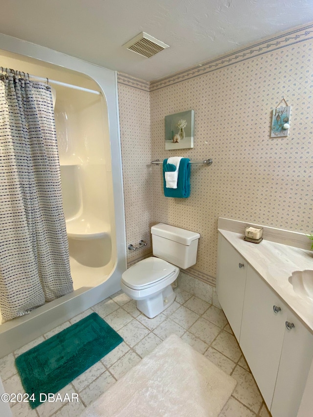 bathroom with toilet, a shower with curtain, vanity, and tile patterned floors