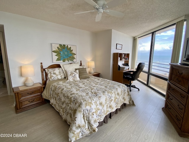 3023 S Atlantic Ave Unit 4070, Daytona Beach Shores, FL 32118 - bedroom with expansive windows, access to exterior, light wood-style flooring, a textured ceiling, and a desk