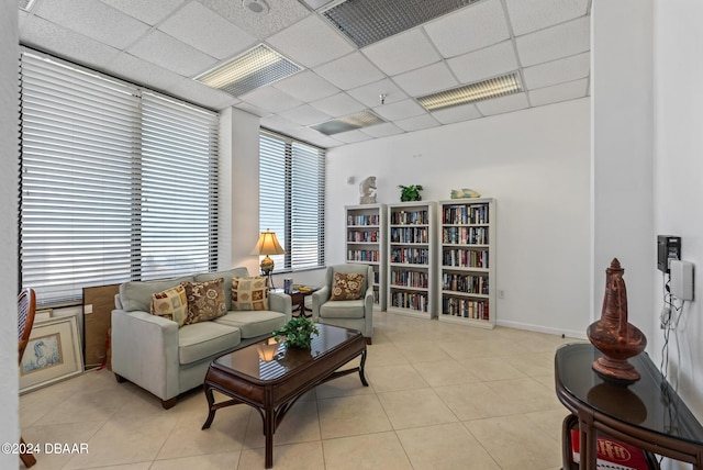 living room featuring light tile patterned flooring and a paneled ceiling