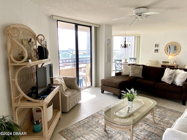 3023 S Atlantic Ave Unit 4070, Daytona Beach Shores, FL 32118 - living room featuring plenty of natural light, a chandelier, ceiling fan, a textured ceiling, and light wood-style flooring