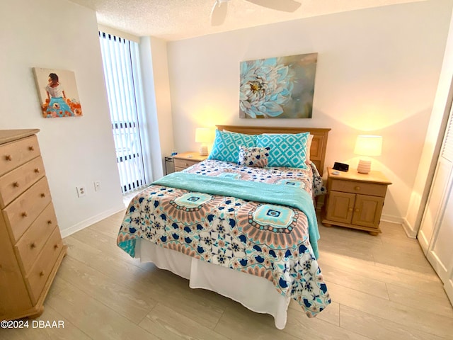 bedroom with light wood-type flooring, a textured ceiling, and ceiling fan