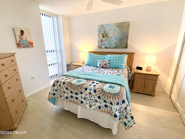 3023 S Atlantic Ave Unit 4070, Daytona Beach Shores, FL 32118 - bedroom featuring light wood-type flooring, multiple windows, baseboards, and a textured ceiling