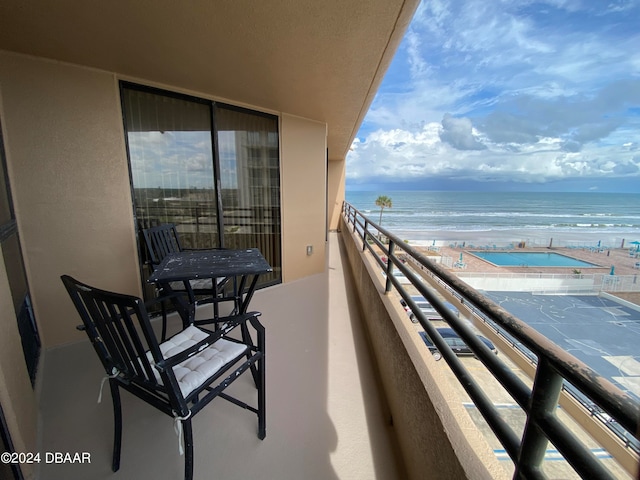 balcony with a water view and a beach view