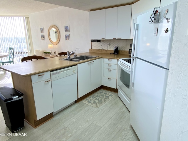 3023 S Atlantic Ave Unit 4070, Daytona Beach Shores, FL 32118 - kitchen featuring white appliances, a peninsula, a sink, tasteful backsplash, and light countertops
