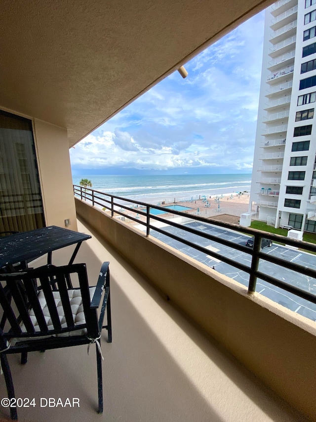 balcony featuring a water view and a beach view