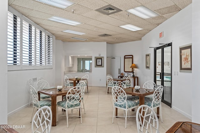 tiled dining room featuring a drop ceiling