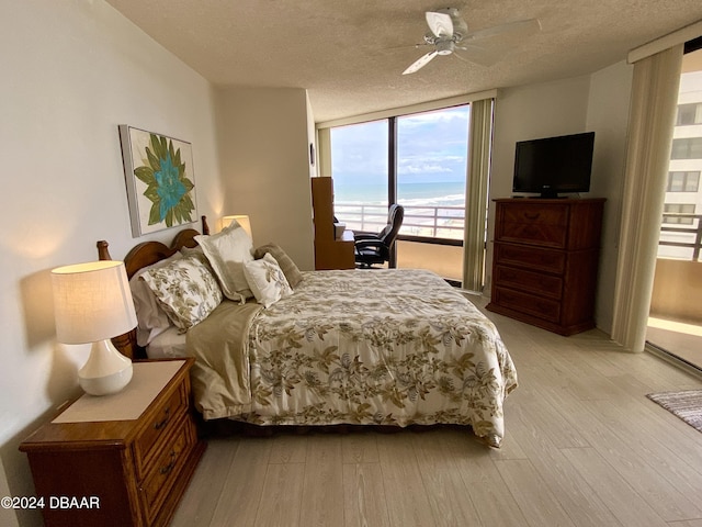 3023 S Atlantic Ave Unit 4070, Daytona Beach Shores, FL 32118 - bedroom with light wood finished floors, a textured ceiling, and ceiling fan