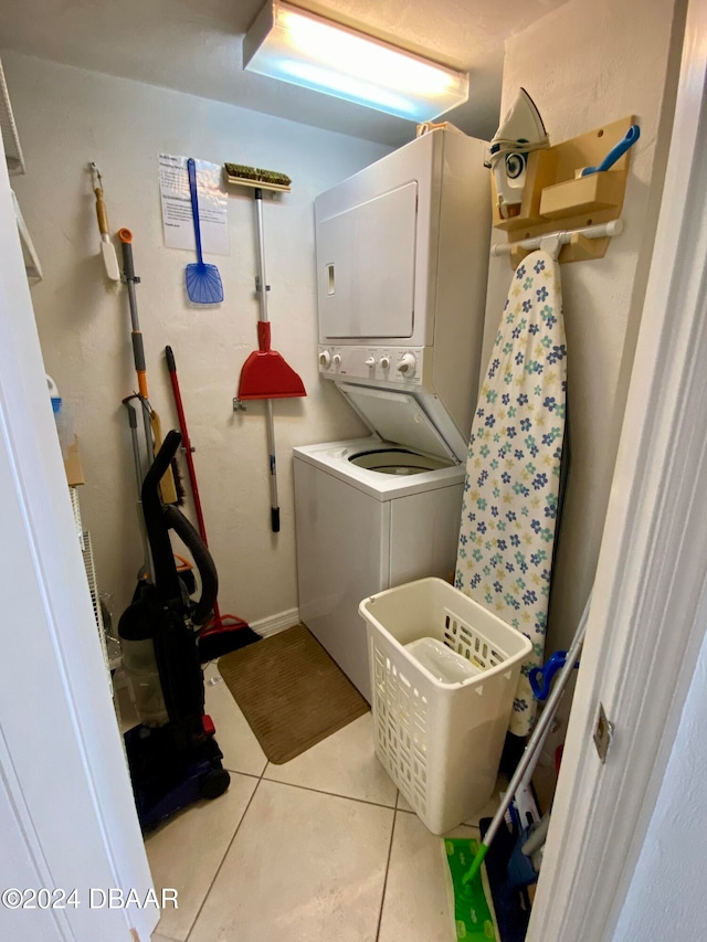 washroom featuring stacked washer and clothes dryer and light tile patterned floors