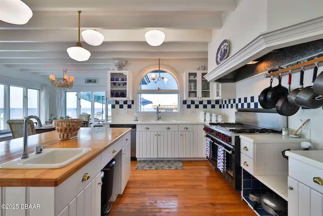 21951 Tarragona Way, Astor, FL 32102 - kitchen with a sink, a chandelier, beam ceiling, stainless steel appliances, and light wood-type flooring