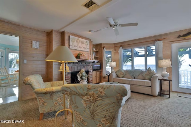 21951 Tarragona Way, Astor, FL 32102 - living area with wood walls, a brick fireplace, carpet flooring, and healthy amount of natural light