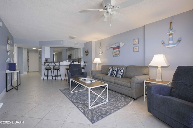 1183 Ocean Shore Blvd Unit 602, Ormond Beach, FL 32176 - living room featuring light tile patterned floors, a ceiling fan, a textured ceiling, and baseboards